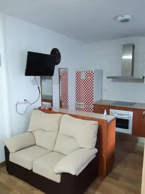 a living room with a couch and a kitchen at Apartamento Zona Carrefour in El Puerto de Santa María