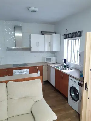 a kitchen with a couch and a washing machine at Apartamento Zona Carrefour in El Puerto de Santa María