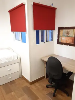 a bedroom with a desk and a chair next to a bed at Apartamento Zona Carrefour in El Puerto de Santa María