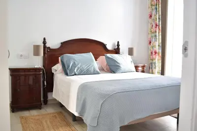 a bedroom with a bed with blue and pink pillows at Apartamento La Discusión de Veedor 12 in Cádiz