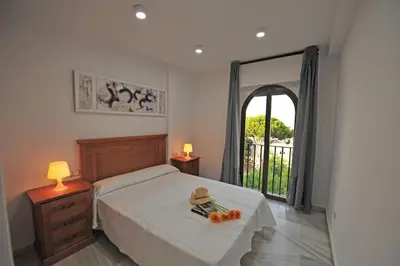 a bedroom with a bed with a table and a window at Playa Santa María 3 Dormitorios 2 Baños in Cádiz