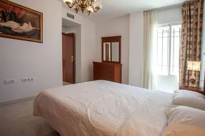 a bedroom with a white bed and a window at Sanlucar Misericordia Centro in Sanlúcar de Barrameda