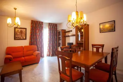 a living room with a dining room table and a couch at Sanlucar Misericordia Centro in Sanlúcar de Barrameda