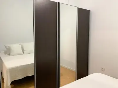 a mirror next to a bed in a room at Apartamento Centro Costa de la Luz in Sanlúcar de Barrameda