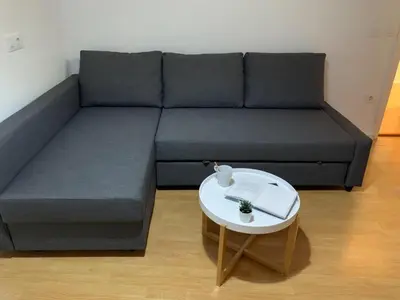 a couch with a table and a book on it at Apartamento Centro Costa de la Luz in Sanlúcar de Barrameda