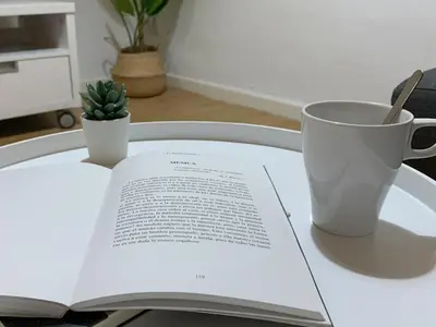an open book on a table with a coffee cup at Apartamento Centro Costa de la Luz in Sanlúcar de Barrameda