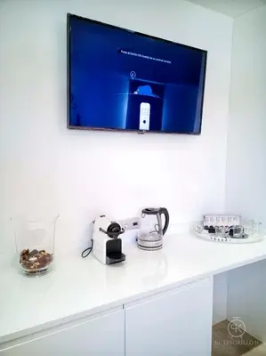 a tv on a wall above a kitchen counter at El Tesorillo II in Arcos de la Frontera