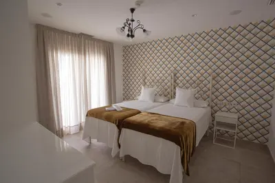 a bedroom with a large white bed and a window at El Tesorillo II in Arcos de la Frontera