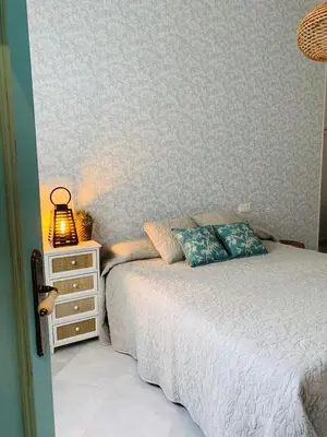 a bedroom with a bed and a night stand with a lamp at Sibilina House centro Jerez in Jerez de la Frontera