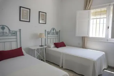 a bedroom with two beds and a window at Amplio alojamiento con magnificas vista a 6 metros de la playa in Chipiona