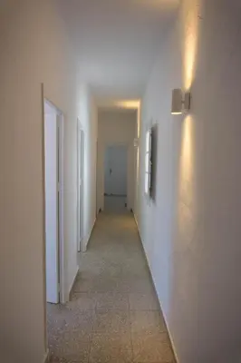 a hallway with white walls and a long hallway at Amplio alojamiento con magnificas vista a 6 metros de la playa in Chipiona