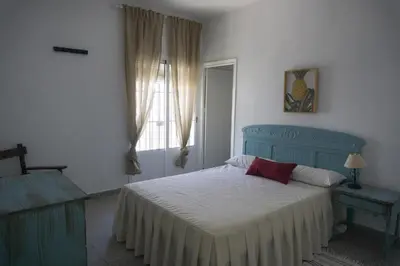 a bedroom with a blue bed and a window at Amplio alojamiento con magnificas vista a 6 metros de la playa in Chipiona