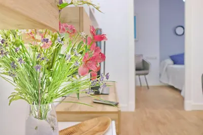 a vase of flowers on a table in a living room at Chalet Isla Azul in Chiclana de la Frontera