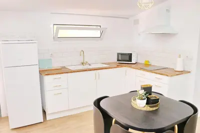 a kitchen with white cabinets and a table with chairs at Chalet Isla Azul in Chiclana de la Frontera