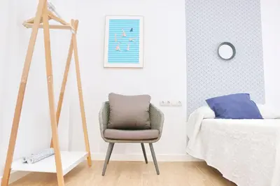 a bedroom with a chair next to a bed at Chalet Isla Azul in Chiclana de la Frontera
