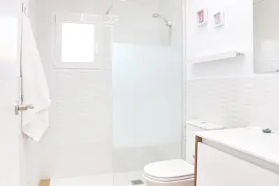 a white bathroom with a toilet and a sink at Chalet Isla Azul in Chiclana de la Frontera