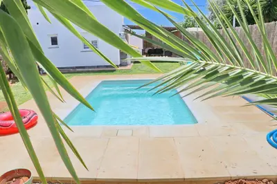 a small swimming pool with a palm tree next to it at Chalet Isla Azul in Chiclana de la Frontera