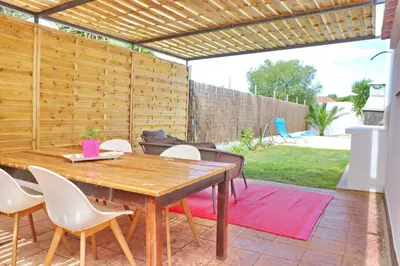 a patio with a wooden table and chairs at Chalet Isla Azul in Chiclana de la Frontera