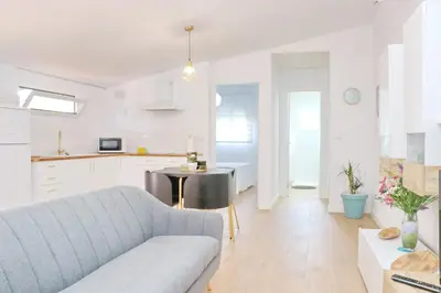 a living room and kitchen with a couch and a table at Chalet Isla Azul in Chiclana de la Frontera