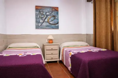 two beds in a room with purple sheets at Chalet 2 dormitorios con piscina privada in Conil de la Frontera