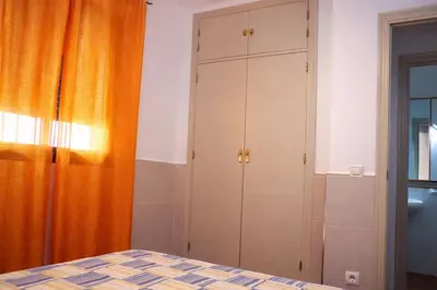 a bedroom with a bed and a cabinet at Chalet 2 dormitorios con piscina privada in Conil de la Frontera