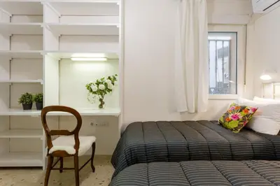 a small bedroom with a bed and a chair at BLUE Atlantic Family Home by Cadiz4Rentals in Cádiz