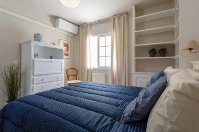 a bedroom with a blue bed and a window at BLUE Atlantic Family Home by Cadiz4Rentals in Cádiz