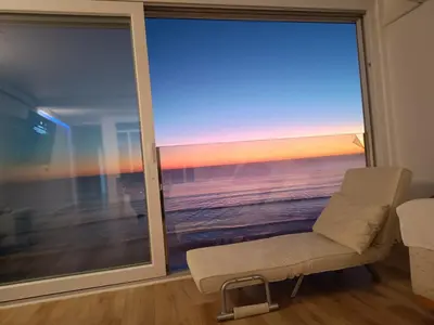 a room with a chair and a view of the ocean at Cielo y Mar infinito in El Puerto de Santa María