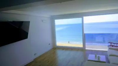 a living room with a large window with a view of the beach at Cielo y Mar infinito in El Puerto de Santa María