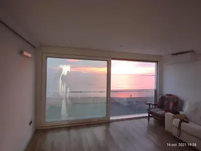 a living room with a large window and a couch at Cielo y Mar infinito in El Puerto de Santa María