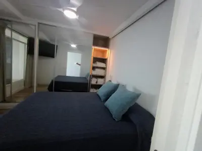 a bedroom with a bed with blue sheets and a mirror at Cielo y Mar infinito in El Puerto de Santa María