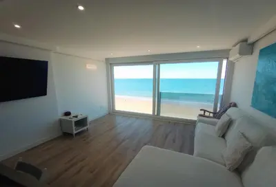 a living room with a couch and a view of the beach at Cielo y Mar infinito in El Puerto de Santa María