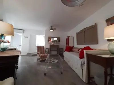 a bedroom with a bed with red pillows and a desk at Ático Baños del Carmen in Cádiz