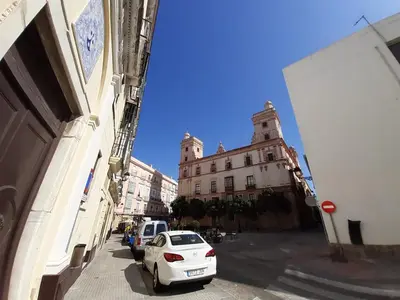 a white car parked on a street next to a building at Ático Baños del Carmen in Cádiz