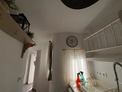 a room with a clock on the wall and a window at Ático Baños del Carmen in Cádiz