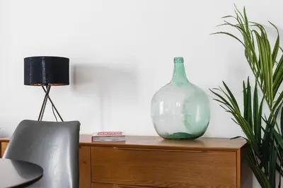 a green glass vase sitting on top of a wooden cabinet at Apartamento San Juan, Parking privado in Jerez de la Frontera