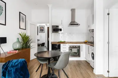 a kitchen with a table and chairs in a room at Apartamento San Juan, Parking privado in Jerez de la Frontera