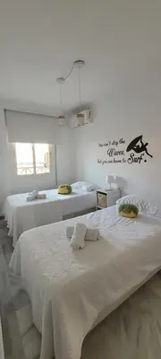 a room with three beds and a sign on the wall at ARENA & SOUL SUITe in El Puerto de Santa María