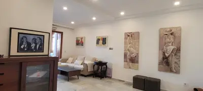 a living room with a couch and paintings on the wall at ARENA & SOUL SUITe in El Puerto de Santa María