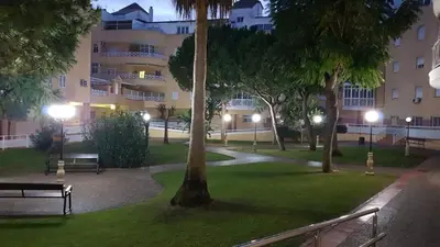 a park with benches in front of a building at night at ARENA & SOUL SUITe in El Puerto de Santa María
