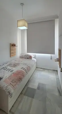 a bedroom with a bed in a white room at ARENA & SOUL SUITe in El Puerto de Santa María