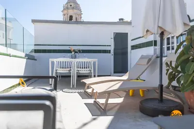 a balcony with a table and chairs on a building at Atico Catedral by Cadiz Time in Cádiz