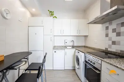 a white kitchen with a sink and a dishwasher at Atico Catedral by Cadiz Time in Cádiz
