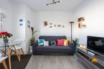 a living room with a couch with colorful pillows at Atico Catedral by Cadiz Time in Cádiz