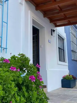 a house with pink flowers in front of a door at Casa Izaro in Sanlúcar de Barrameda