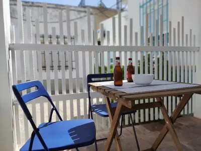 a wooden table with two bottles and a bowl on a balcony at Casa Izaro in Sanlúcar de Barrameda