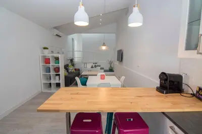 a living room with a table and purple chairs at Casa Izaro in Sanlúcar de Barrameda