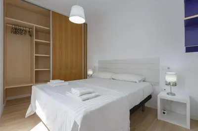a white bedroom with a large bed with white sheets at COLON15 Family Home by Cadiz4Rentals in Cádiz