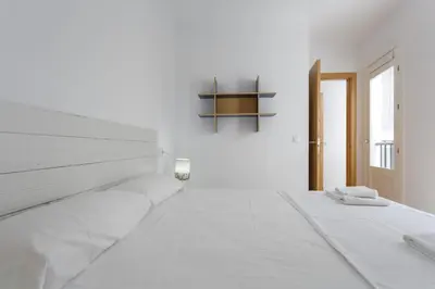 a white bedroom with a white bed and a window at COLON15 Family Home by Cadiz4Rentals in Cádiz