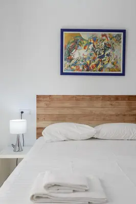 a white bed with a painting on the wall at COLON15 Family Home by Cadiz4Rentals in Cádiz
